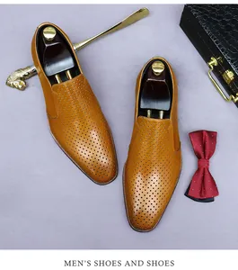 Detail view of brown hollowed leather oxfords with breathable brogue patterns and shoe tree