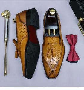 Vista dall'alto di scarpe brogue in pelle marrone con nappe decorative e motivi traforati