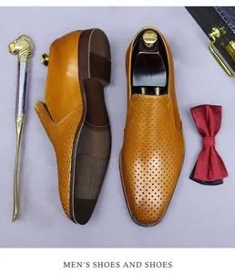 Close-up of brown leather loafers with breathable perforations and metal shoehorn