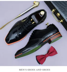 Close-up of black patent leather dress shoes with orange trim and wood-grain heel detail