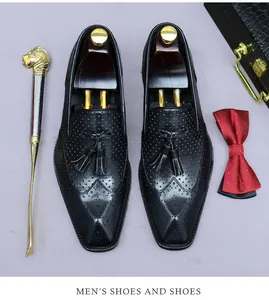 Dettaglio di scarpe brogue nere con nappe e texture in pelle raffinata da uomo