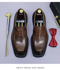 Draufsicht auf dunkelbraune Leder-Loafer mit quadratischer Kappe und Business-Accessoires