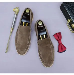 Vue de dessus de mocassins en daim marron avec coutures et embauchoirs en bois