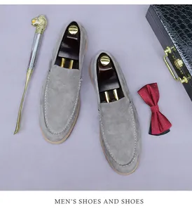 Détail macro de mocassins en daim gris avec surpiqûres blanches et cuir mat de qualité