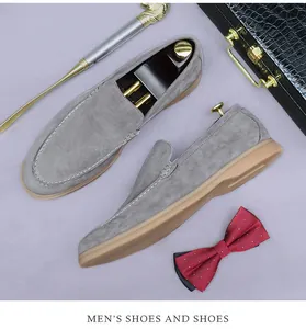 Vue à plat de mocassins en daim gris pour hommes avec accessoires pro sur fond violet