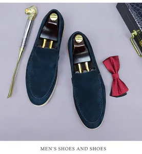 Vue de dessus des mocassins en daim bleu foncé avec embauchoirs et accessoires homme