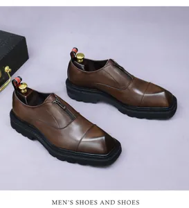 Detailed view of brown leather dress shoes with thick rubber soles and metal zipper design