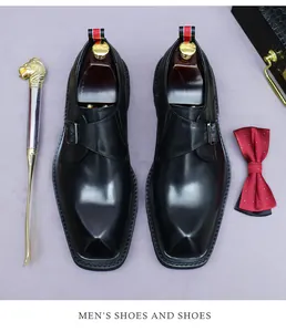 Close-up of black leather monk strap shoe with silver metal buckle and square toe detail