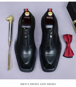 Detail of square-toe leather shoes with front zipper and decorative lion head shoehorn