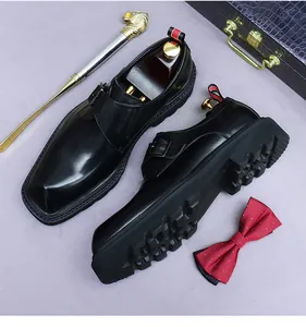 Close-up of black leather monk strap shoe with platform sole and golden shoehorn