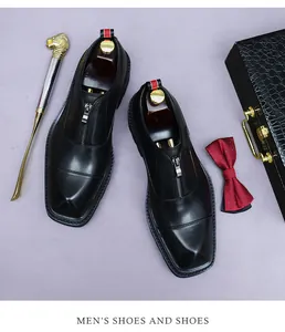 Top view of black leather formal shoes with zipper and retro square toe on purple desk