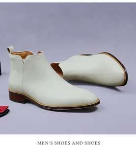 Detail view of cream leather Chelsea boots featuring side elastic V-cut and pull tabs