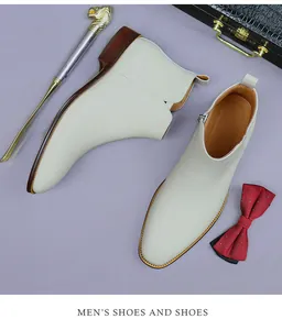Mens white leather zip boots styled with luxury suitcase and gold lion shoehorn detail