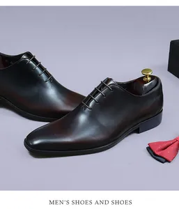 Détail de chaussures Richelieu en cuir dégradé marron avec nœud papillon et boîte