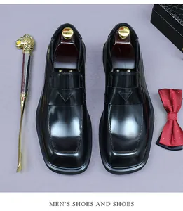 Close-up of black leather business loafers with a square toe and metal shoehorn