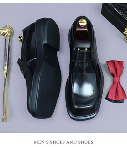 Top view of formal black leather dress shoes with wooden trees and accessories