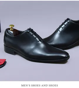 Gros plan d'Oxfords en cuir noir poli avec laçage à 5 œillets et embauchoirs en bois