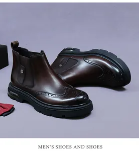 Detailed view of brown leather Chelsea boots with brogue carving and chunky rubber sole