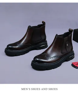 Detail of deep brown leather Chelsea boots with classic brogue carving and rubber sole