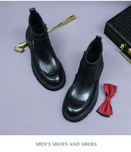 Primer plano de botines de cuero negro para hombre con cremallera y accesorios