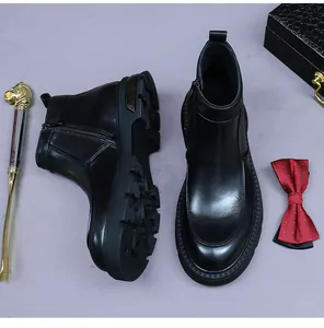 Detalle de botines Chelsea de cuero negro con cremalleras laterales y suelas de goma gruesas