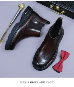 Detail of dark brown leather Chelsea boots with brogue wingtip carving and elastic side