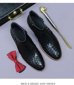 Dettaglio degli stivali in pelle intrecciata nera da uomo con cerniera e decoro business