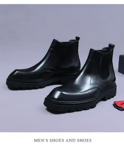 Close-up of black leather Chelsea boots with elastic sides and a thick rubber lug sole
