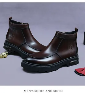 Detalle de bota de cuero marrón oscuro con cremallera lateral y patrón geométrico grabado