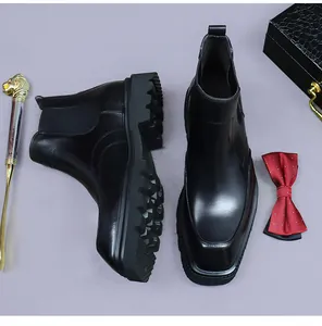 Detail view of black leather Chelsea boots with thick lug sole and elastic side panel