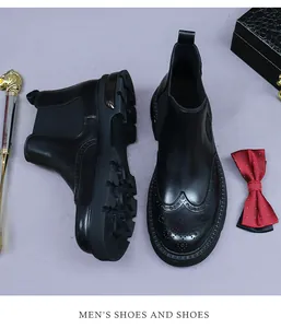 Close-up of black leather Chelsea boots featuring wingtip brogue patterns and rubber soles