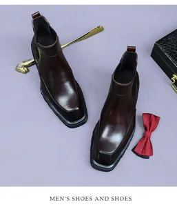 Close-up of luxury brown leather Chelsea boots with high-gloss finish and formal accessories