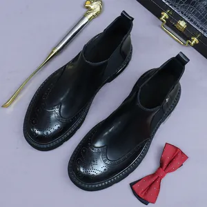 Classic men's black leather Chelsea boots with wingtip brogue patterns and elastic side panels