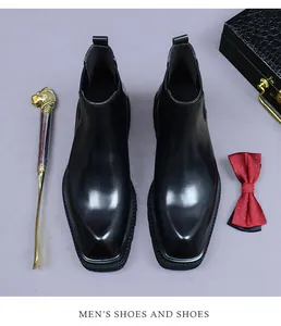 Polished black leather Chelsea boots with square toe shown with luxury accessories