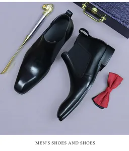 Bottines Chelsea en cuir noir avec chausse-pied doré et nœud papillon sur fond violet