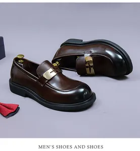 Detail of dark brown leather loafers with burnished toe and gold metal buckle detail