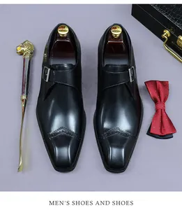 Détail de chaussures monk en cuir noir avec perforations brogues et accessoires business