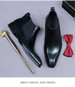 Détails de bottines Chelsea en cuir noir avec chausse-pied lion doré et nœud papillon