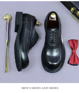 Flat lay of black leather brogue shoes with decorative bow tie and golden shoehorn