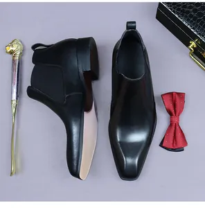 Détail de bottines Chelsea en cuir avec bande élastique, cravate et mallette luxe