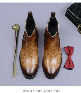 Classic brown leather Chelsea boots styled with a lion head shoehorn and bow tie