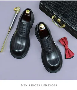 Top view of black leather oxford shoes with a luxury briefcase and silk bow tie