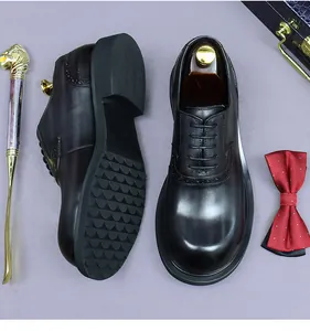 Macro shot of black leather brogue shoes with non-slip rubber soles and bowtie