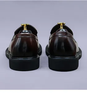 Rear view showing the heel construction and glossy finish of men's leather loafers