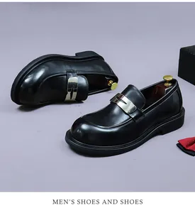 Close-up of black leather loafers with silver metal buckle and slip-on design