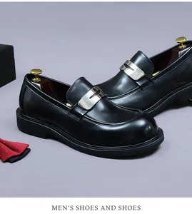Detail of men's black leather loafers featuring a silver metal buckle and rounded toe