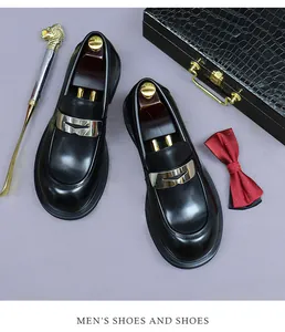 Top view of black leather loafers with silver metal buckle and gentleman accessories