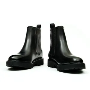Minimalist black leather Chelsea boots with platform lug sole and elastic side panel