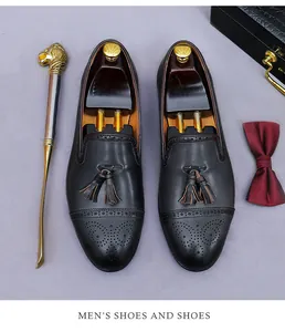 Vista superior de mocasines de cuero negro con detalles brogue y borlas dobles
