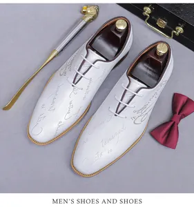 Top view of white leather oxford shoes with English letter print and golden shoehorn